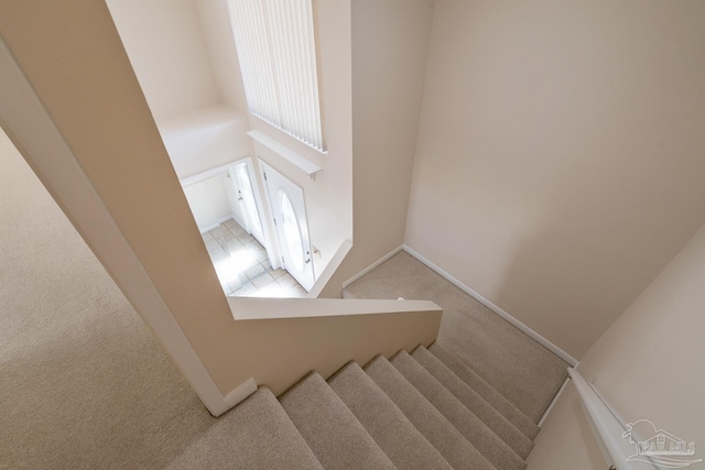 staircase with carpet floors and baseboards