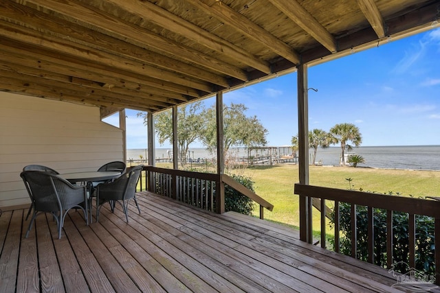 wooden terrace featuring a water view and a lawn