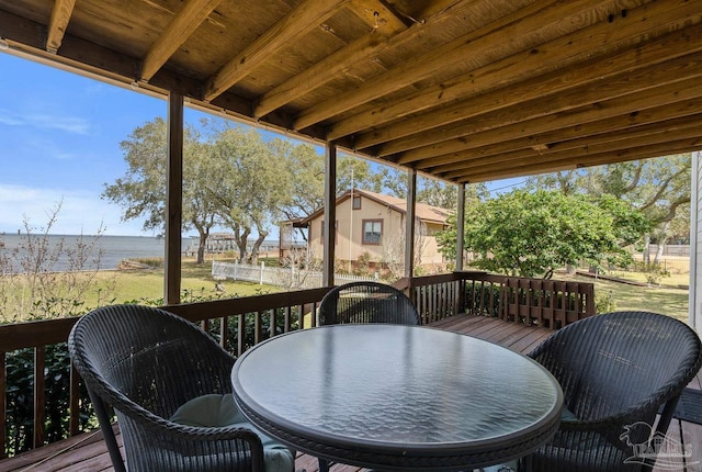 wooden terrace with outdoor dining space and a water view