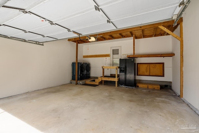 garage with a garage door opener and black fridge