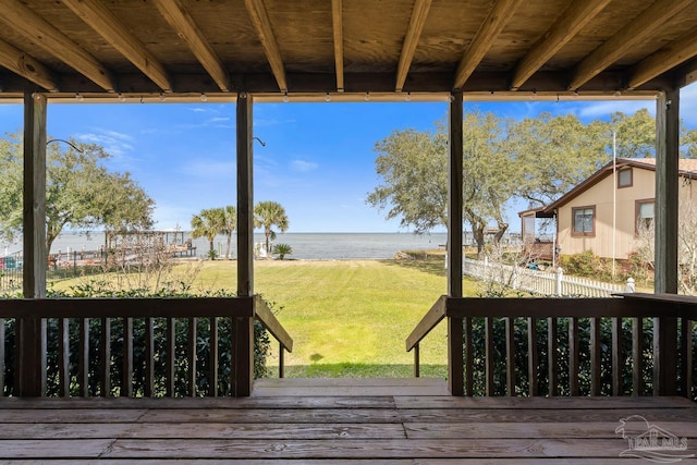 wooden terrace featuring a water view, fence, and a yard