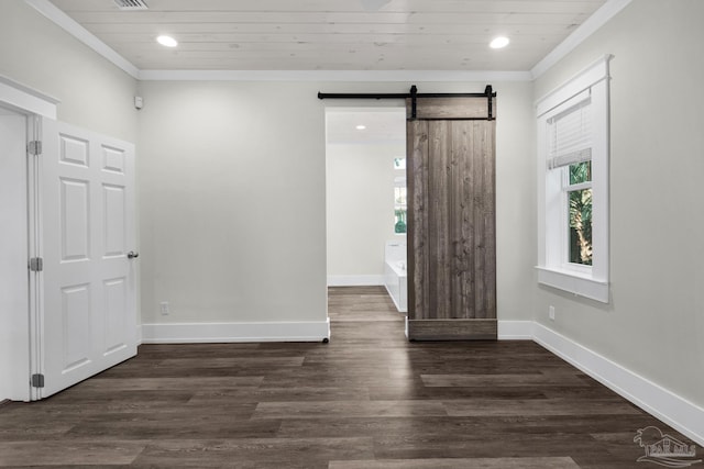 unfurnished bedroom with crown molding, dark hardwood / wood-style floors, and a barn door