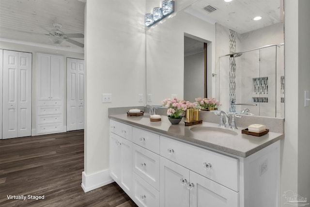 bathroom with hardwood / wood-style flooring, vanity, a shower with door, and ceiling fan