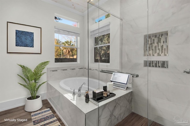 bathroom with hardwood / wood-style flooring and tiled bath