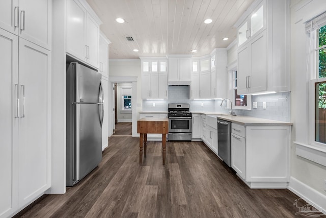 kitchen featuring appliances with stainless steel finishes, white cabinetry, backsplash, dark hardwood / wood-style flooring, and wood ceiling