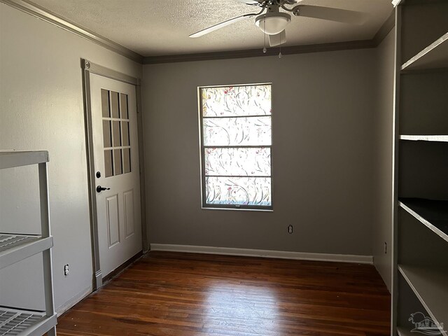 empty room featuring crown molding, dark hardwood / wood-style flooring, a wealth of natural light, and ceiling fan