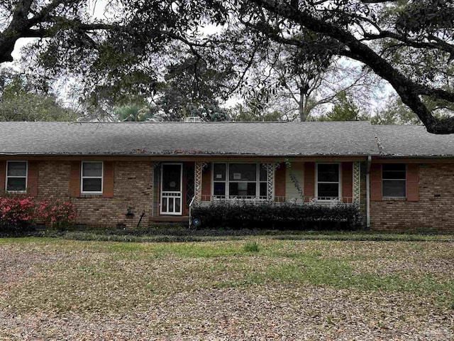 ranch-style house with brick siding, crawl space, a front yard, and a shingled roof