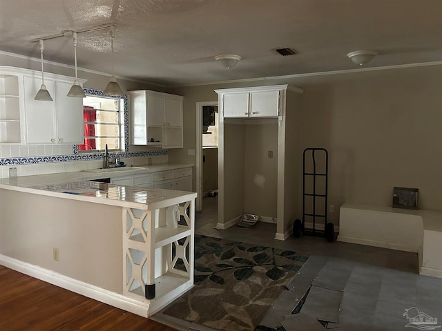 kitchen featuring tasteful backsplash, kitchen peninsula, white cabinets, dark hardwood / wood-style floors, and hanging light fixtures