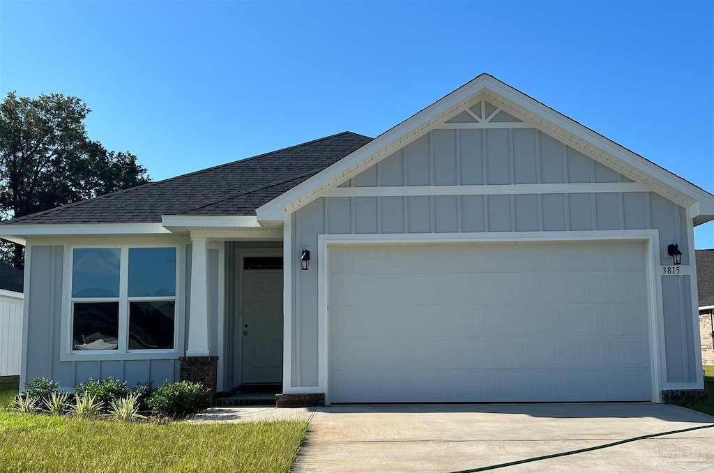 view of front of property featuring driveway, a shingled roof, board and batten siding, and an attached garage