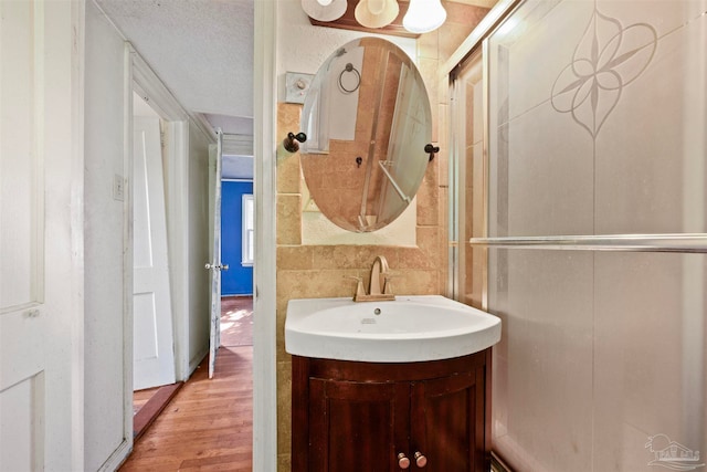 bathroom featuring vanity, hardwood / wood-style floors, and a textured ceiling