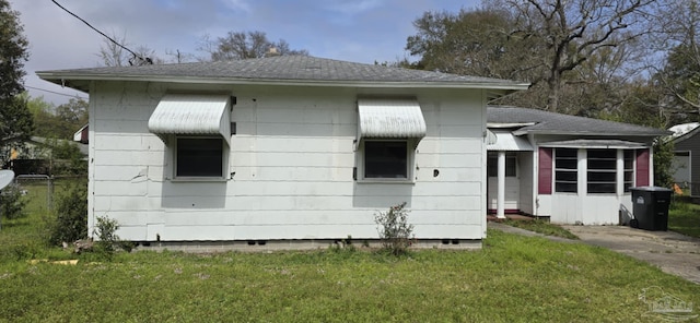 view of home's exterior featuring crawl space, a lawn, and a shingled roof