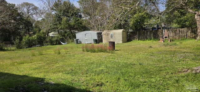 view of yard with a fenced backyard, a shed, and an outdoor structure