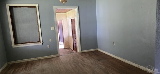 unfurnished room with baseboards and wood finished floors