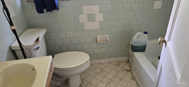 bathroom featuring a sink, toilet, a bathtub, and tile patterned flooring