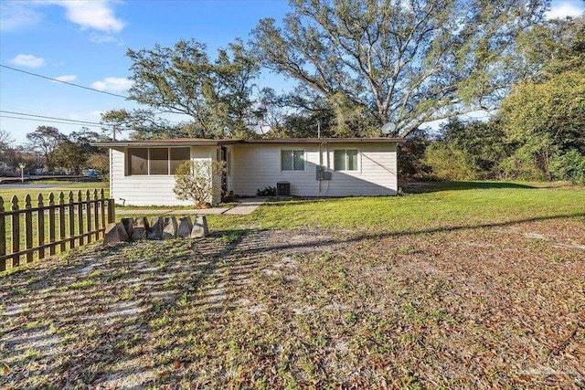 exterior space with cooling unit, a yard, and fence