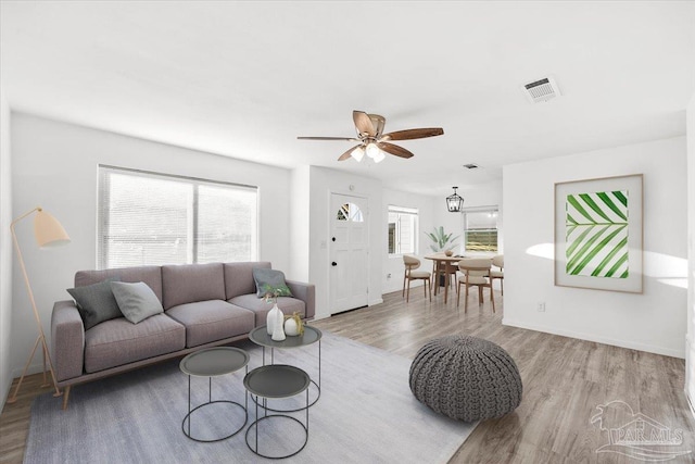 living area featuring plenty of natural light, wood finished floors, and visible vents