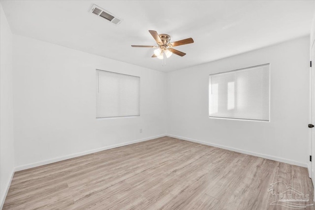 unfurnished room featuring visible vents, a ceiling fan, baseboards, and wood finished floors