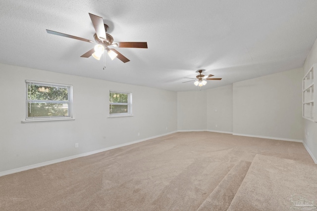 carpeted spare room with ceiling fan and a textured ceiling