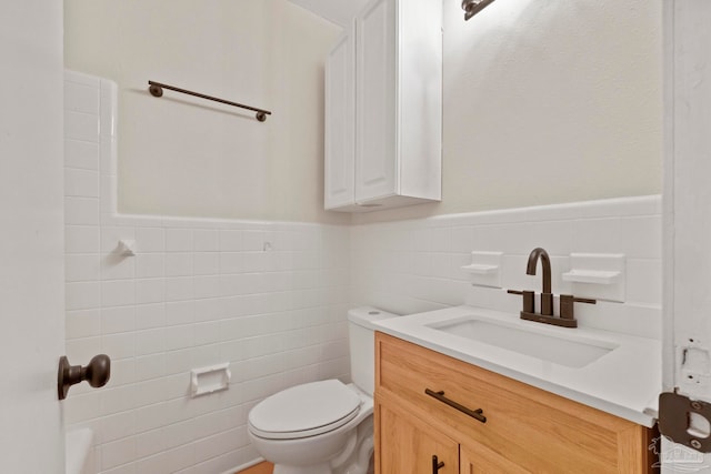 bathroom featuring vanity, tile walls, and toilet