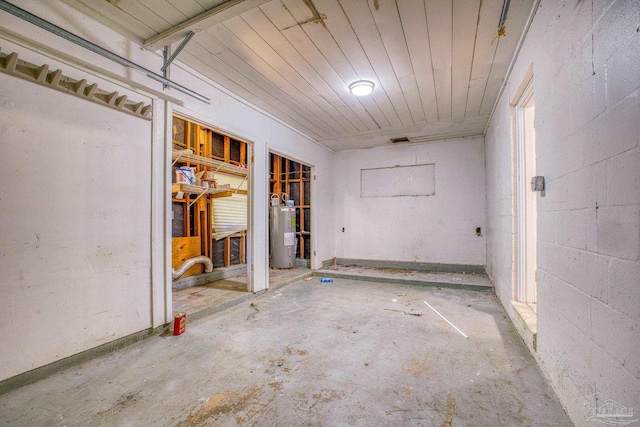 interior space featuring concrete floors, wood ceiling, and electric water heater