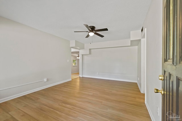 spare room featuring ceiling fan, a textured ceiling, and light wood-type flooring