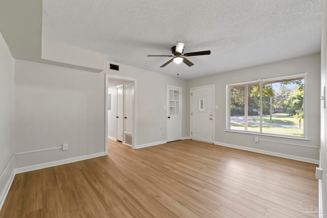 spare room with light hardwood / wood-style floors, a textured ceiling, and ceiling fan