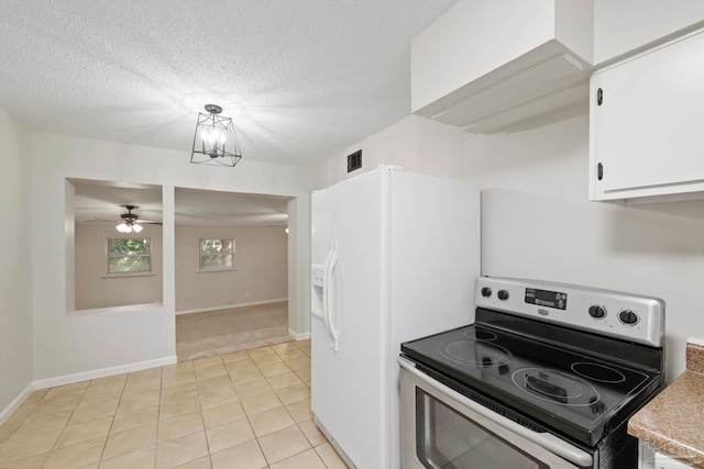 kitchen with white cabinets, pendant lighting, light tile patterned floors, a textured ceiling, and electric range