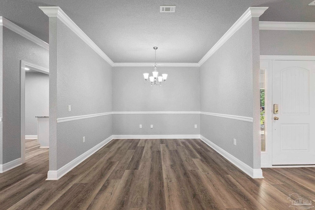 591 Nowak Rd, Cantonment, FL 32533 - unfurnished dining area with dark wood-type flooring, a chandelier, crown molding, baseboards, and a textured ceiling
