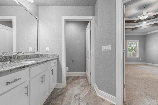 591 Nowak Rd, Cantonment, FL 32533 - bathroom featuring toilet, vanity, a textured wall, a ceiling fan, and baseboards