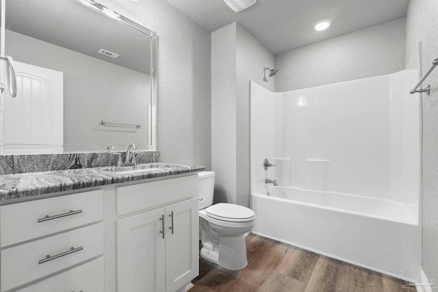 591 Nowak Rd, Cantonment, FL 32533 - full bath featuring a textured wall, toilet, wood finished floors, vanity, and tub / shower combination