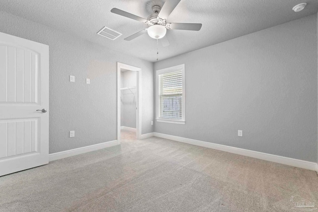 591 Nowak Rd, Cantonment, FL 32533 - unfurnished bedroom with carpet floors, a spacious closet, a textured ceiling, a closet, and ceiling fan