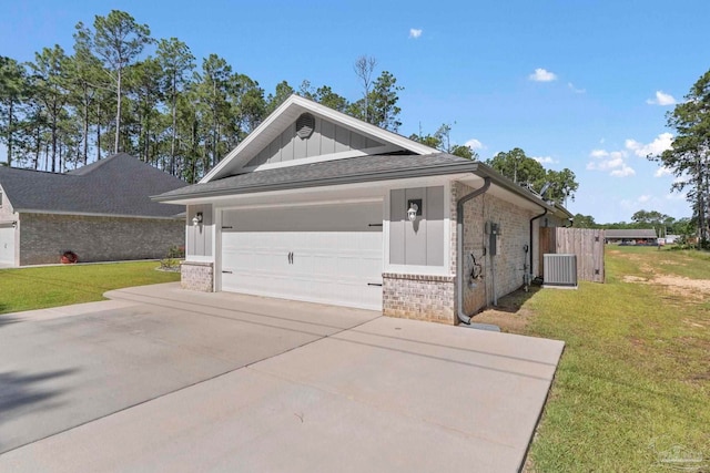 591 Nowak Rd, Cantonment, FL 32533 - view of front of home with board and batten siding, central AC unit, driveway, brick siding, and a front lawn