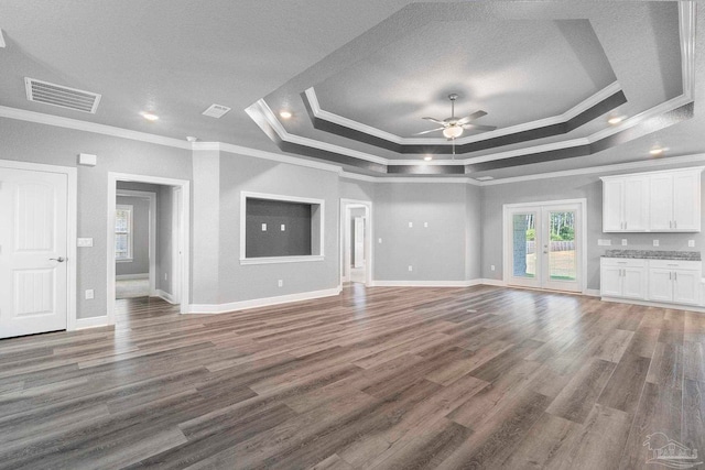 591 Nowak Rd, Cantonment, FL 32533 - unfurnished living room featuring a raised ceiling, crown molding, ceiling fan, wood finished floors, and baseboards