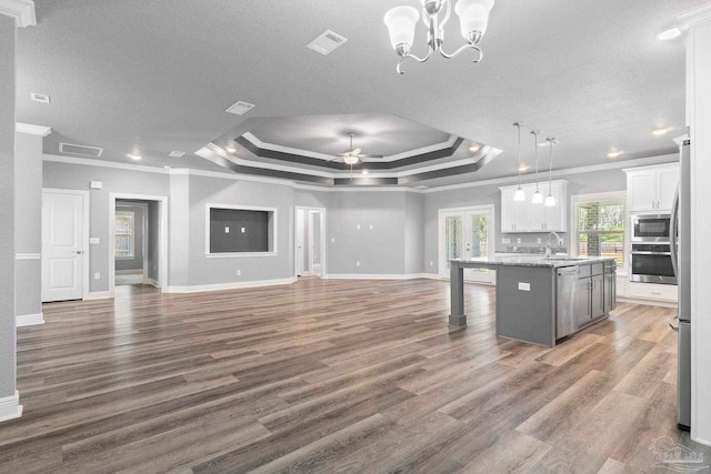591 Nowak Rd, Cantonment, FL 32533 - kitchen featuring appliances with stainless steel finishes, crown molding, open floor plan, a center island with sink, and a raised ceiling