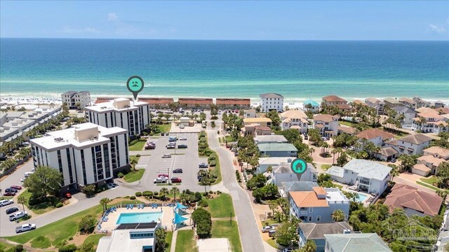 birds eye view of property with a water view and a beach view