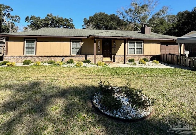 single story home with a garage, brick siding, a chimney, and a front yard