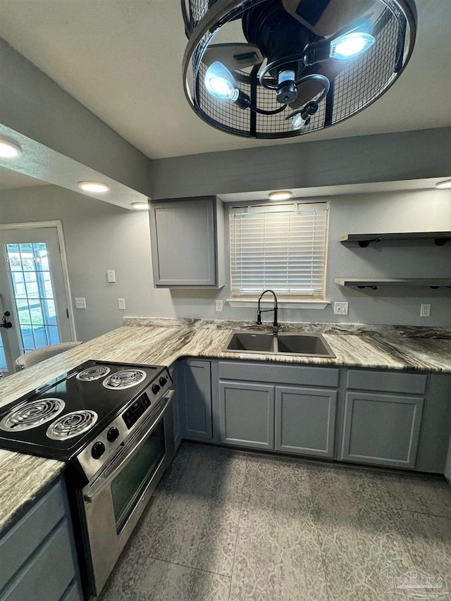 kitchen featuring gray cabinets, light countertops, stainless steel electric range oven, and a sink