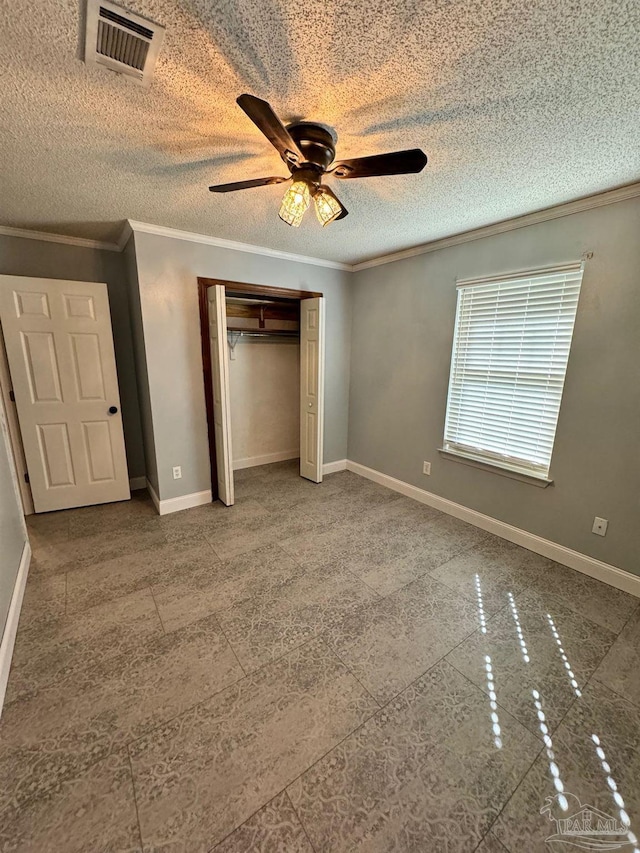 unfurnished bedroom featuring a textured ceiling, visible vents, baseboards, ornamental molding, and a closet