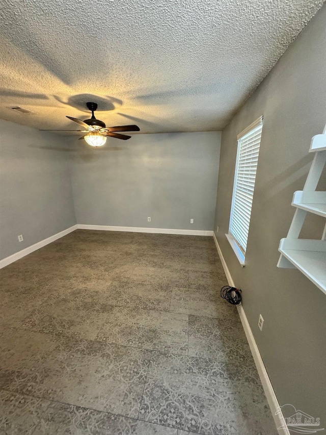 empty room featuring visible vents, ceiling fan, a textured ceiling, and baseboards