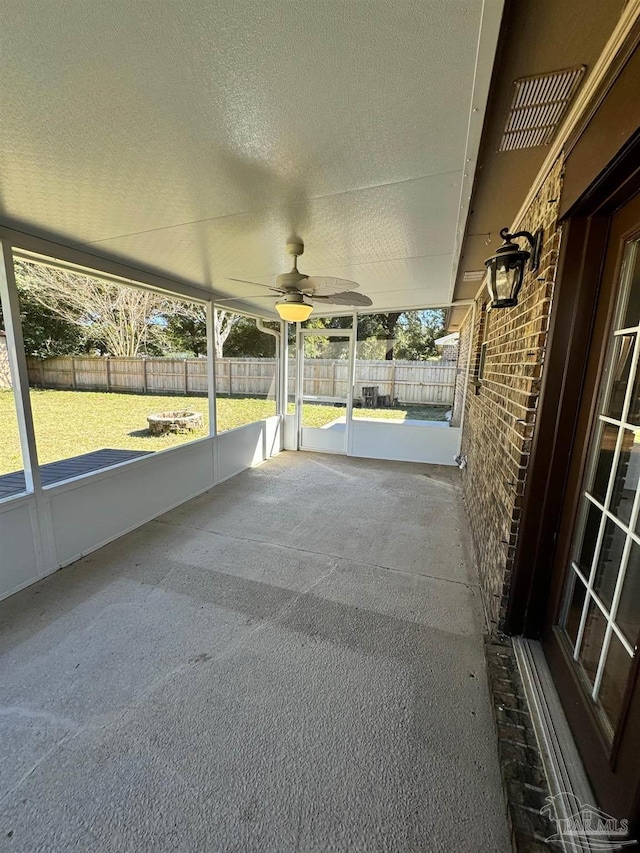 unfurnished sunroom with visible vents and a ceiling fan