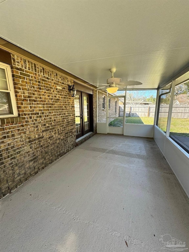 unfurnished sunroom with a ceiling fan