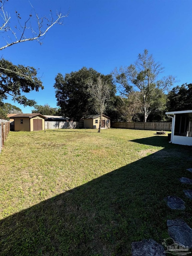 view of yard featuring a shed, a fenced backyard, and an outdoor structure