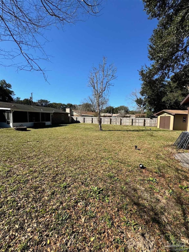 view of yard with a shed, an outdoor structure, and fence