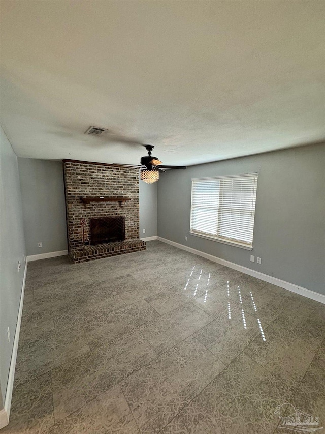 unfurnished living room featuring a ceiling fan, visible vents, a fireplace, and baseboards