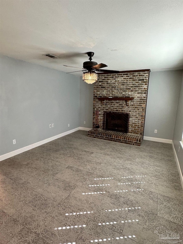 unfurnished living room featuring a textured ceiling, a brick fireplace, visible vents, and baseboards