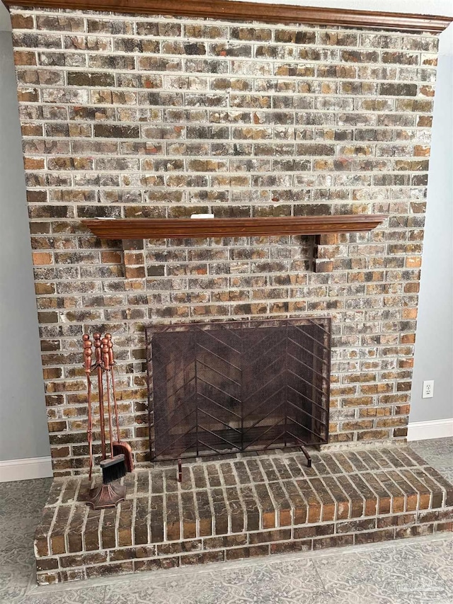 details featuring a brick fireplace and baseboards