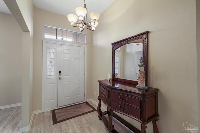 foyer entrance with light hardwood / wood-style flooring and a chandelier