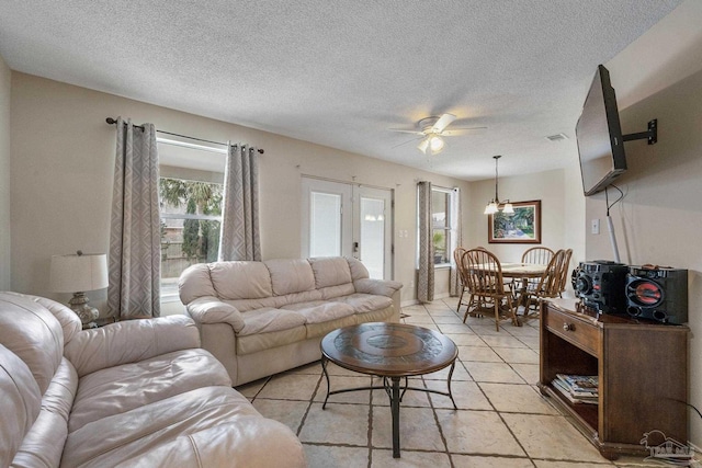 living room with ceiling fan and a textured ceiling