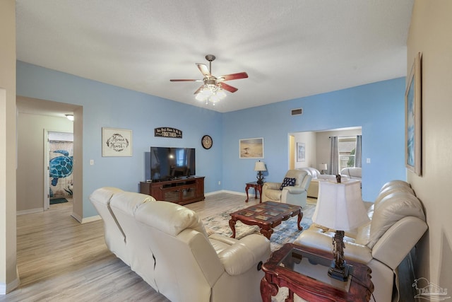 living room featuring ceiling fan and light hardwood / wood-style flooring