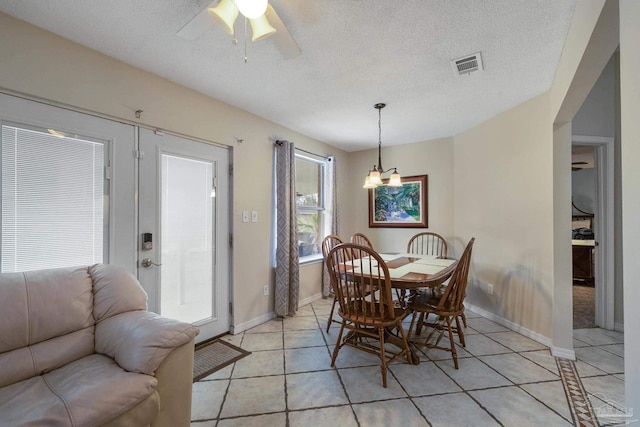 dining area with light tile patterned flooring, ceiling fan, and a textured ceiling